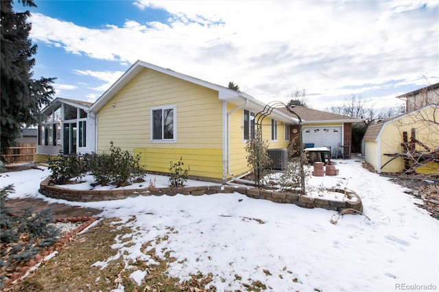 view of front of property featuring a garage and central AC