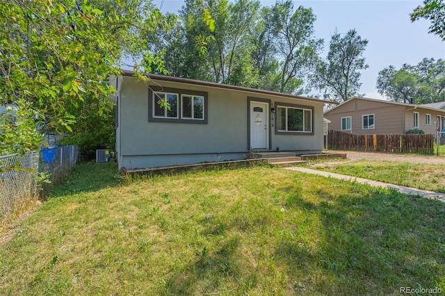view of front of house featuring central AC, a front yard, and fence