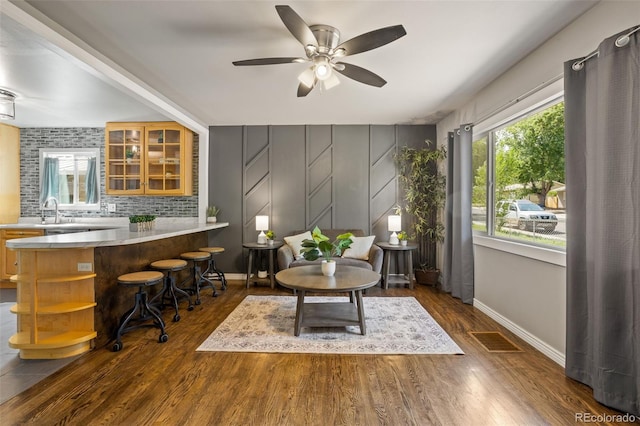 sitting room featuring dark wood-style floors, visible vents, baseboards, and ceiling fan