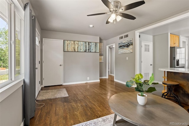foyer entrance with visible vents, wood finished floors, baseboards, and ceiling fan