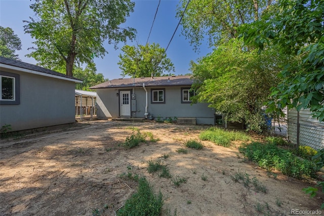 back of house featuring fence and stucco siding