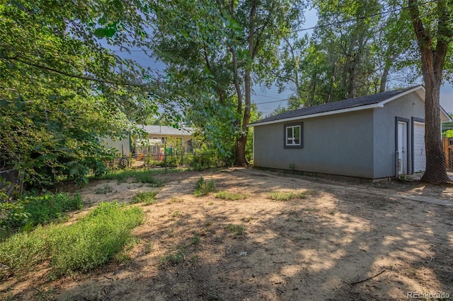 view of yard with an outdoor structure and fence
