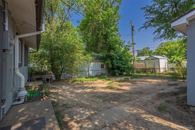 view of yard featuring an outdoor structure and fence