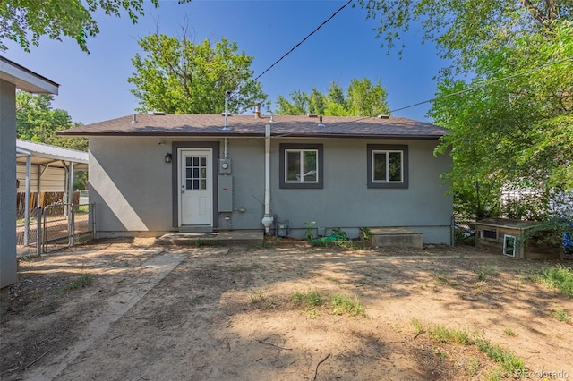 back of property with a gate and fence