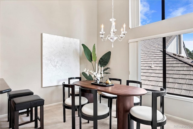 carpeted dining room featuring a notable chandelier and a high ceiling