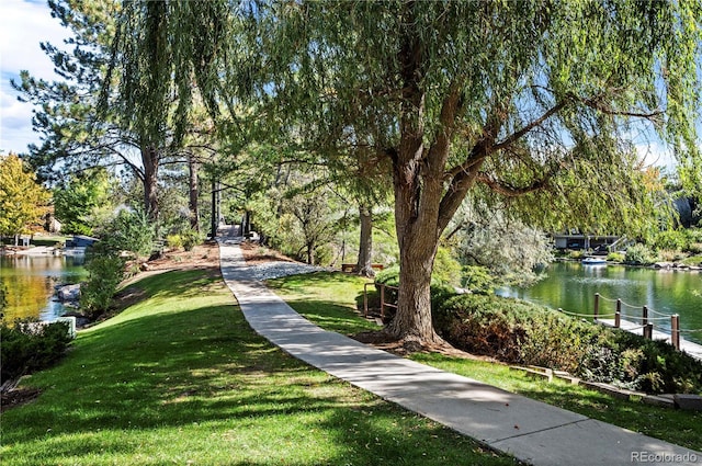 view of community with a lawn and a water view