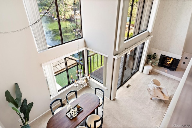 interior space with a towering ceiling, plenty of natural light, and a water view