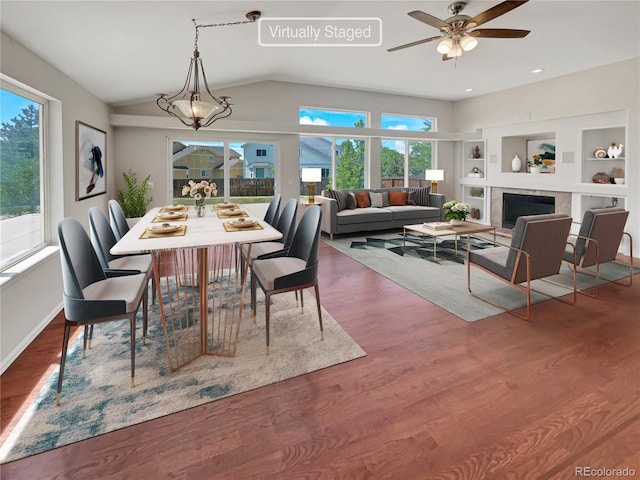 dining room featuring built in features, wood-type flooring, vaulted ceiling, and ceiling fan