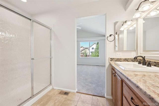 bathroom featuring tile patterned floors, a shower with door, vanity, and vaulted ceiling