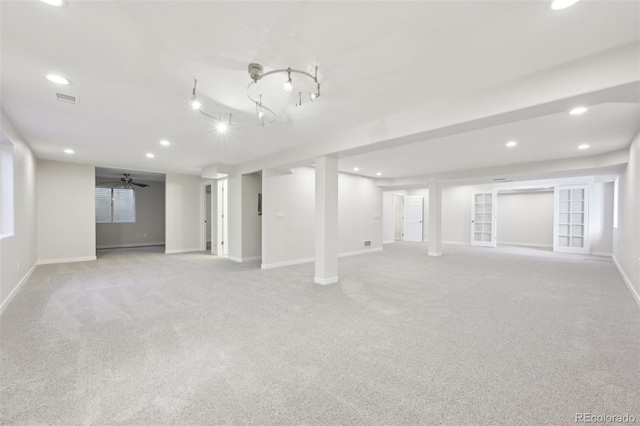 basement featuring ceiling fan and light colored carpet