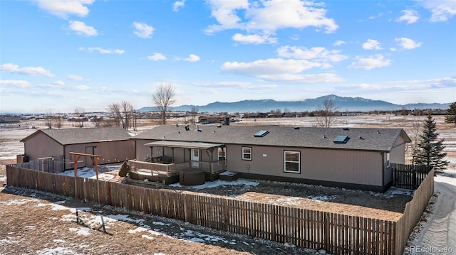 snow covered property featuring a mountain view and a sunroom