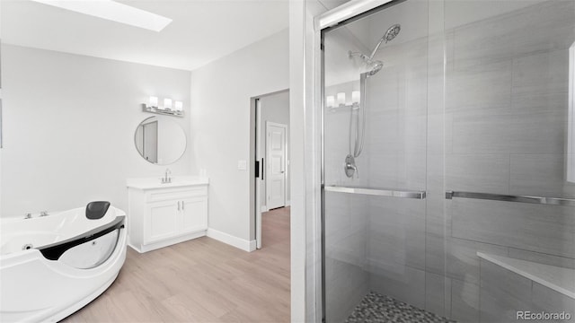 bathroom with a skylight, vanity, wood-type flooring, and a shower with shower door