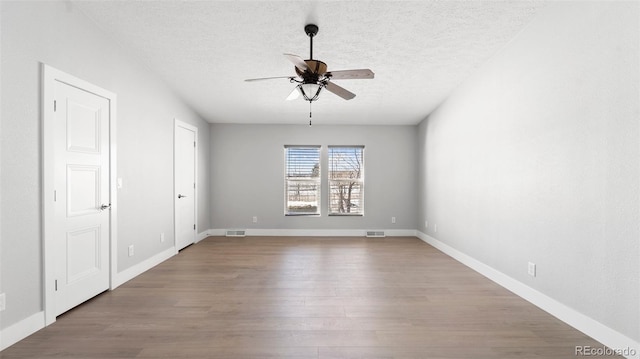 empty room featuring ceiling fan, a textured ceiling, and light hardwood / wood-style floors