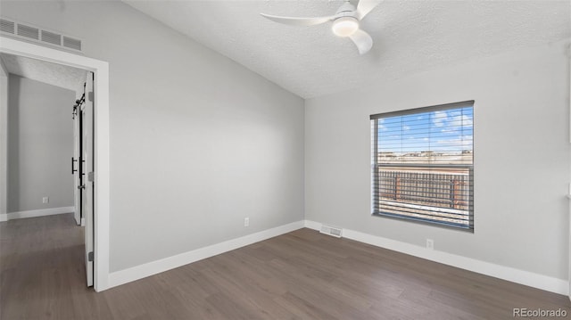 empty room featuring ceiling fan, dark hardwood / wood-style floors, and a textured ceiling