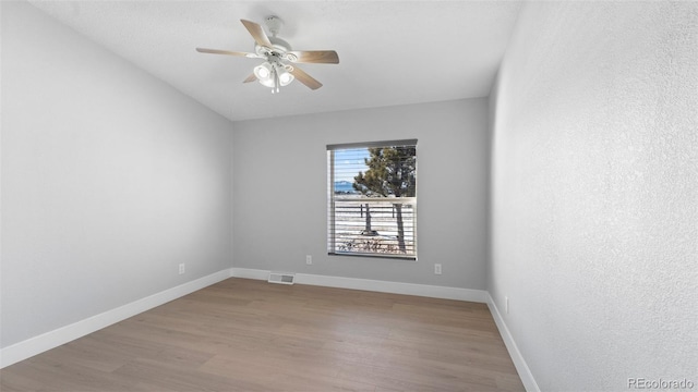 empty room with ceiling fan and light hardwood / wood-style flooring
