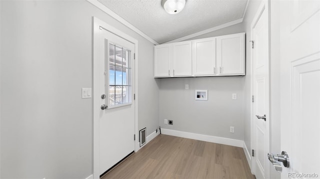 clothes washing area with cabinets, hookup for a washing machine, hookup for an electric dryer, a textured ceiling, and light hardwood / wood-style flooring
