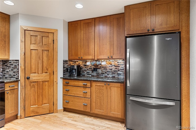 6773 Snowshoe Trl, Evergreen, CO 80439 - kitchen with freestanding refrigerator, brown cabinetry, light wood finished floors, decorative backsplash, and recessed lighting