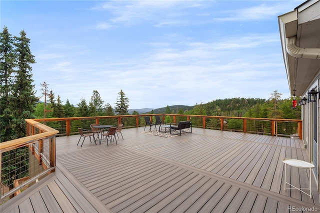 6773 Snowshoe Trl, Evergreen, CO 80439 - deck with outdoor dining area, a fire pit, and a mountain view