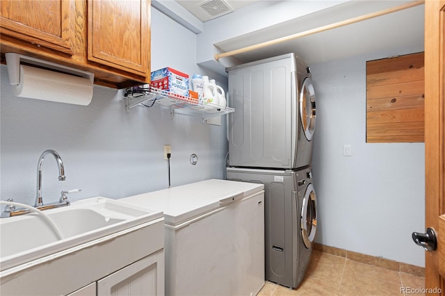 6773 Snowshoe Trl, Evergreen, CO 80439 - laundry area with stacked washer and clothes dryer, cabinet space, and light tile patterned flooring