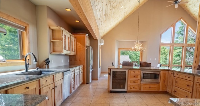 kitchen featuring light tile patterned flooring, sink, hanging light fixtures, stainless steel appliances, and beverage cooler