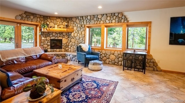 living room featuring plenty of natural light and a stone fireplace