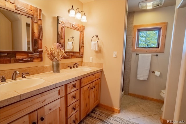 full bathroom featuring a sink, toilet, double vanity, and tile patterned flooring