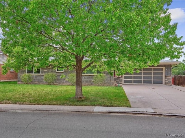 423 Empire St, Aurora, CO 80010 - view of property hidden behind natural elements with concrete driveway and brick siding