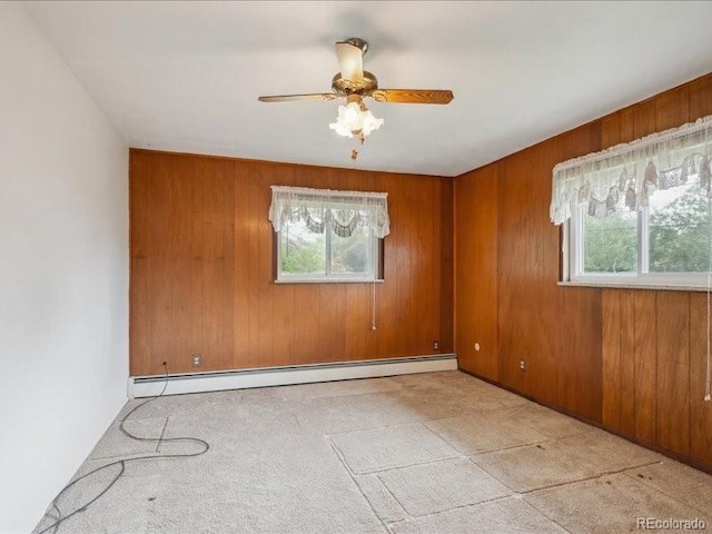 423 Empire St, Aurora, CO 80010 - unfurnished room with a baseboard radiator, ceiling fan, wood walls, and carpet