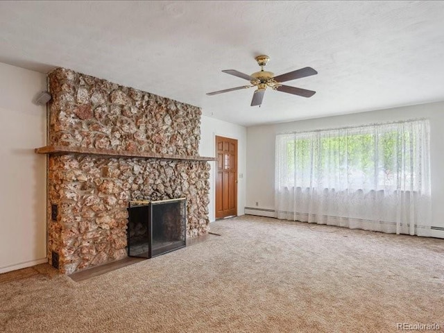 423 Empire St, Aurora, CO 80010 - unfurnished living room with a baseboard heating unit, carpet floors, ceiling fan, a stone fireplace, and baseboards