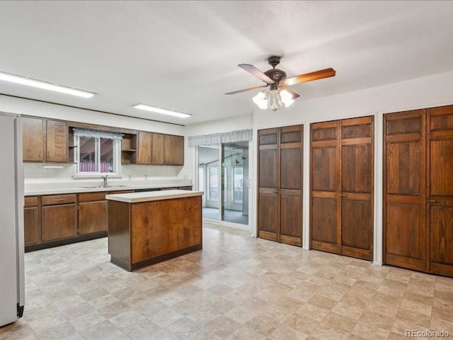 423 Empire St, Aurora, CO 80010 - kitchen with a sink, open shelves, light countertops, a center island, and a ceiling fan