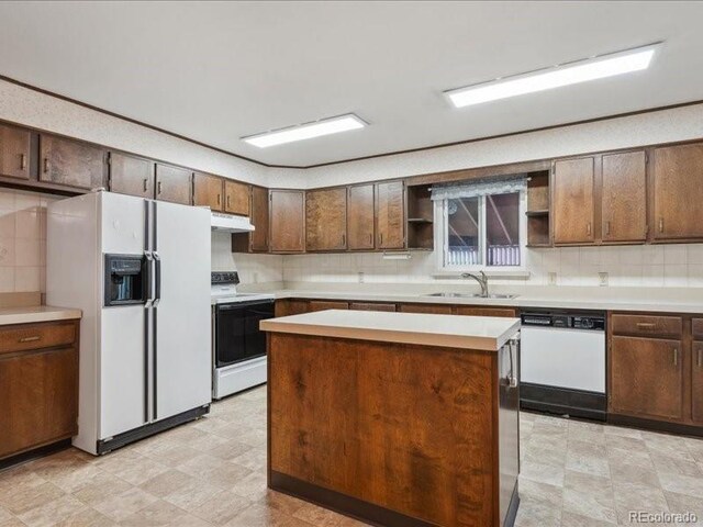 423 Empire St, Aurora, CO 80010 - kitchen with white appliances, a sink, open shelves, under cabinet range hood, and tasteful backsplash