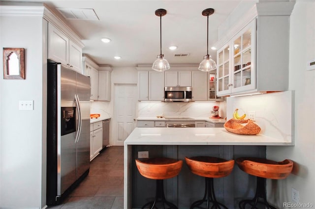 kitchen featuring a peninsula, visible vents, appliances with stainless steel finishes, backsplash, and glass insert cabinets