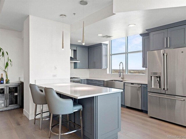 2001 Lincoln St Unit 1822, Denver, CO 80202 - kitchen featuring light countertops, a peninsula, light wood finished floors, stainless steel appliances, and a breakfast bar area