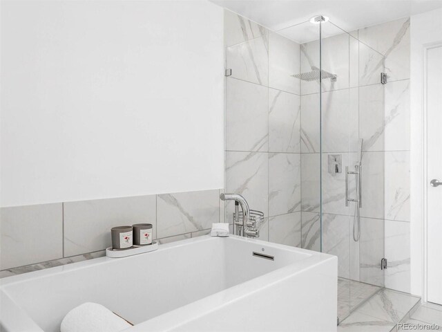 2001 Lincoln St Unit 1822, Denver, CO 80202 - bathroom featuring a soaking tub, marble finish floor, and a shower stall
