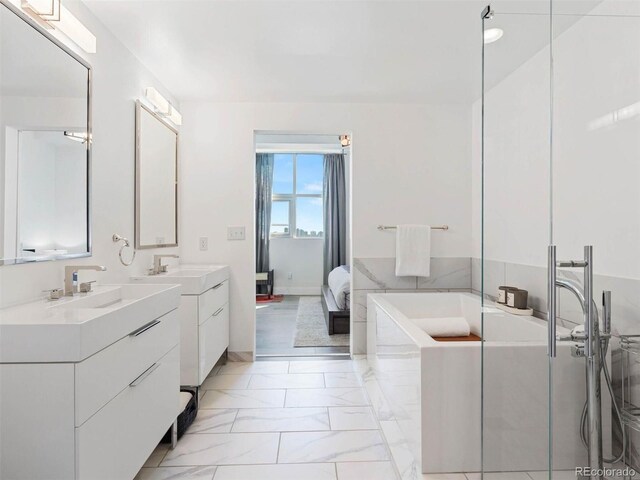 2001 Lincoln St Unit 1822, Denver, CO 80202 - bathroom with marble finish floor, connected bathroom, two vanities, a sink, and a garden tub