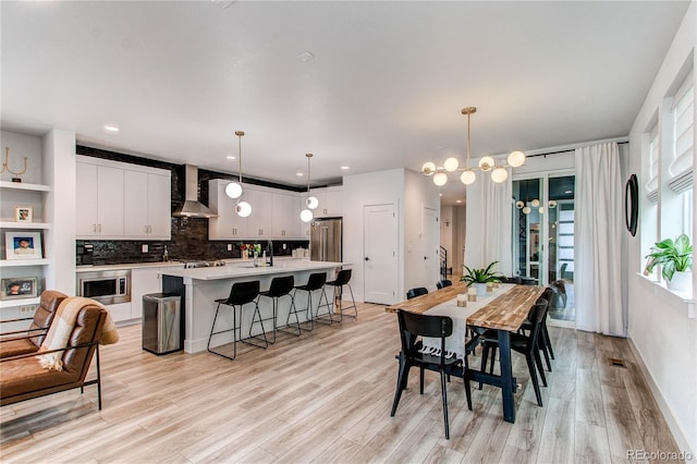 dining room featuring light hardwood / wood-style floors, a notable chandelier, and sink