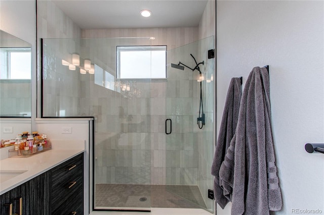 bathroom with vanity and a shower with door