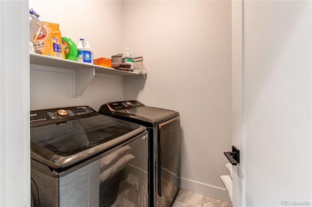 clothes washing area featuring light tile patterned floors and washing machine and dryer