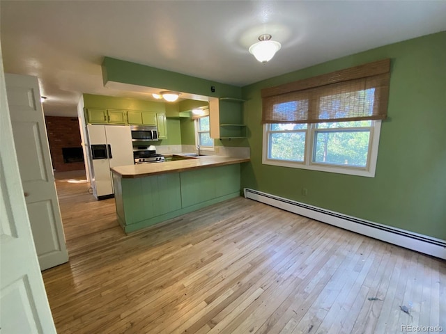 kitchen with light wood-type flooring, green cabinets, stainless steel appliances, kitchen peninsula, and a baseboard heating unit