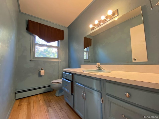 bathroom with wood-type flooring, toilet, vanity, and baseboard heating