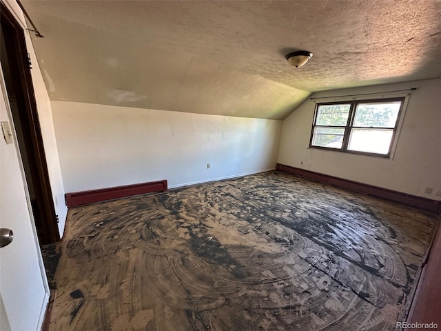 bonus room with vaulted ceiling, a textured ceiling, a baseboard radiator, and baseboards