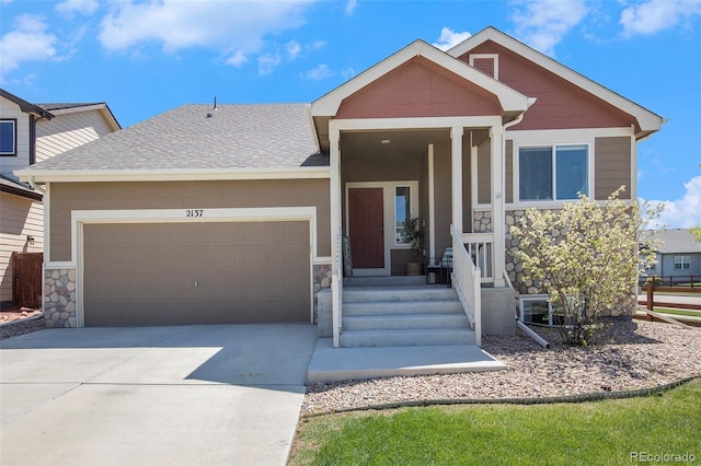 2137 Day Spring Dr, Windsor, CO 80550 - view of front of home with an attached garage, concrete driveway, stone siding, and a shingled roof