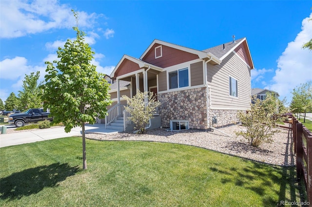 2137 Day Spring Dr, Windsor, CO 80550 - view of front of property featuring stone siding, a front lawn, a porch, and driveway