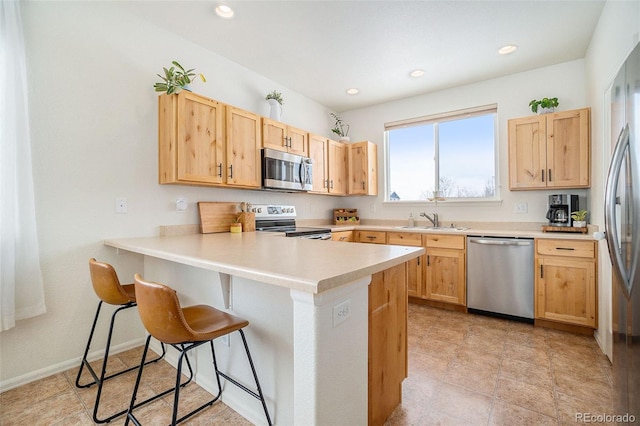 2137 Day Spring Dr, Windsor, CO 80550 - kitchen with stainless steel appliances, a sink, light brown cabinets, a peninsula, and recessed lighting
