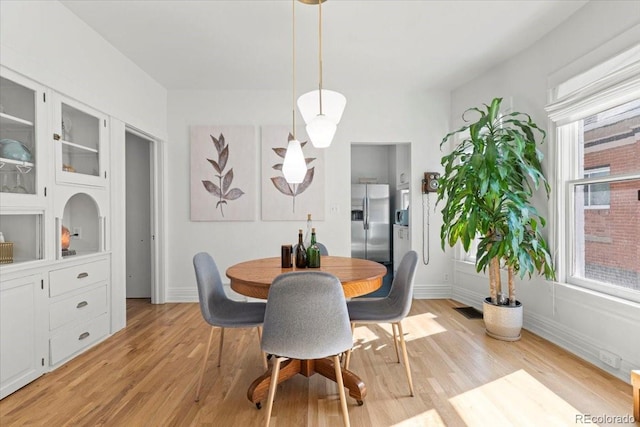 dining area featuring visible vents, baseboards, and light wood-type flooring