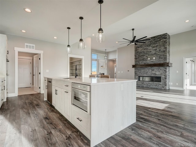 kitchen featuring oven, a kitchen island, white cabinetry, and sink