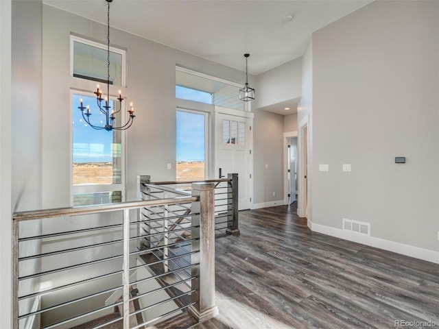 hallway featuring dark hardwood / wood-style floors and an inviting chandelier