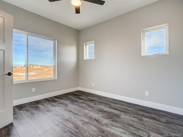 unfurnished room with plenty of natural light, dark wood-type flooring, and ceiling fan