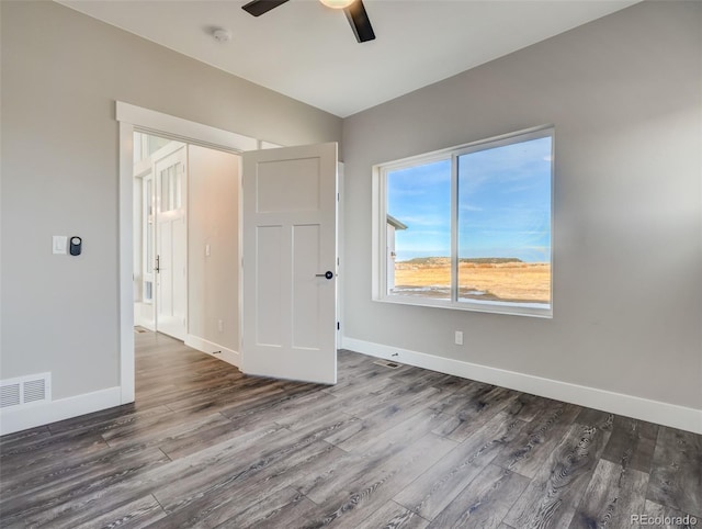 unfurnished room featuring ceiling fan and dark hardwood / wood-style flooring