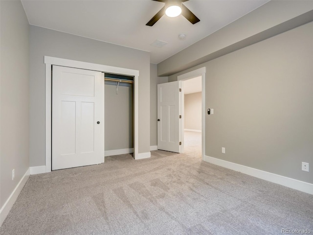 unfurnished bedroom with a closet, light colored carpet, and ceiling fan